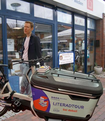 Lennaer Schäfer mit seinem Literad-Lastenrad vor Buchhandlung Förster